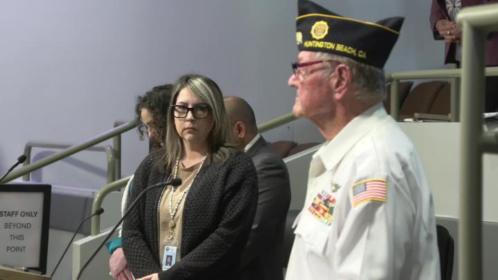 A vet looks on to a crowd while a woman looks back at him.